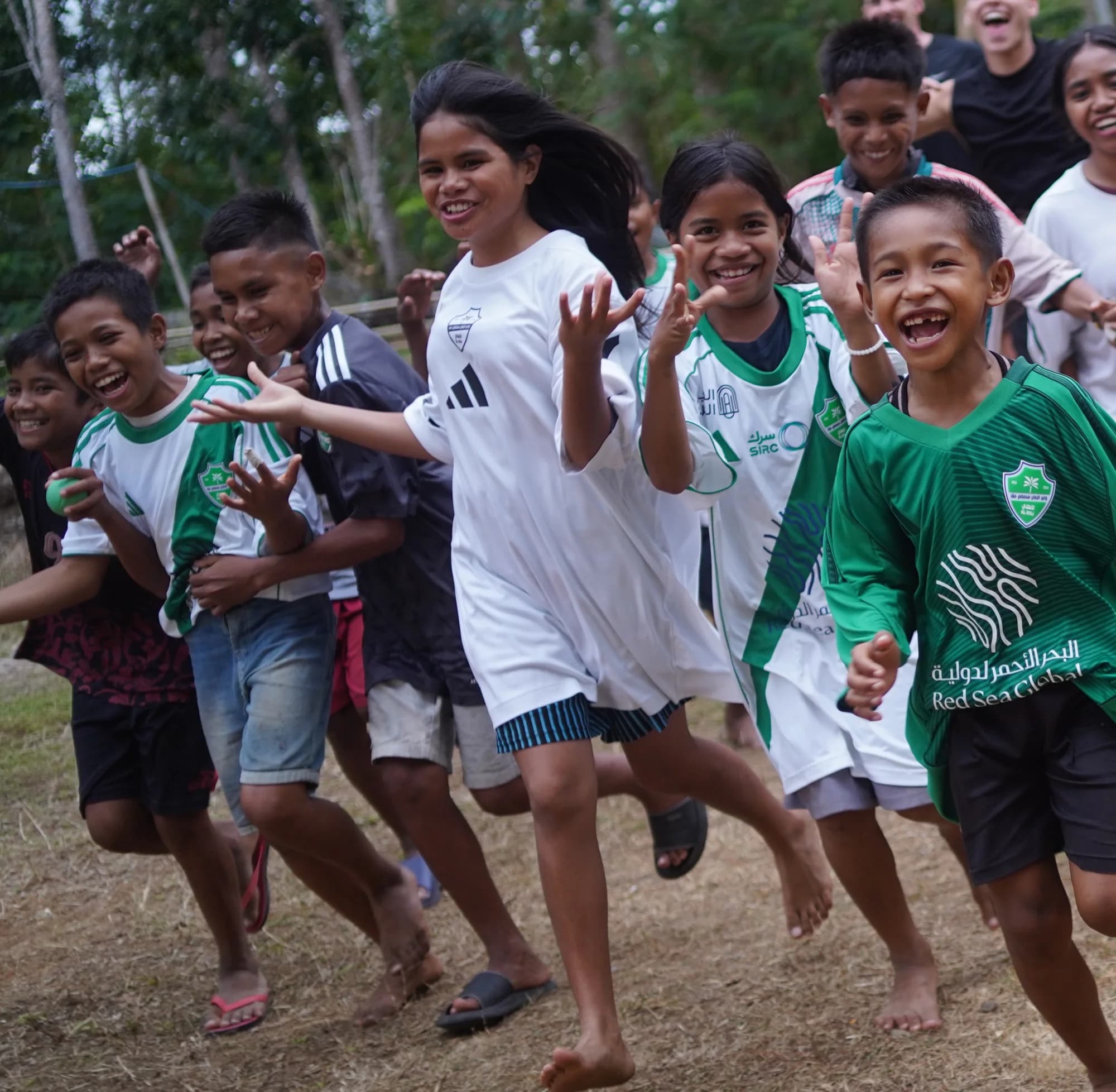 Anak-anak berlari ke arah kamera sambil tertawa di sebuah kampung di Sumba.